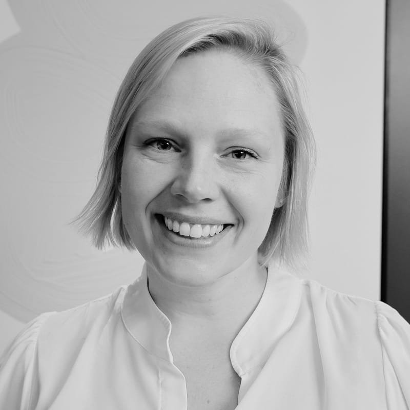Mari Di Peri's headshot in black and white in office space at Aldrich CPAs + Advisors, where she provides audit + attest services to growth companies.