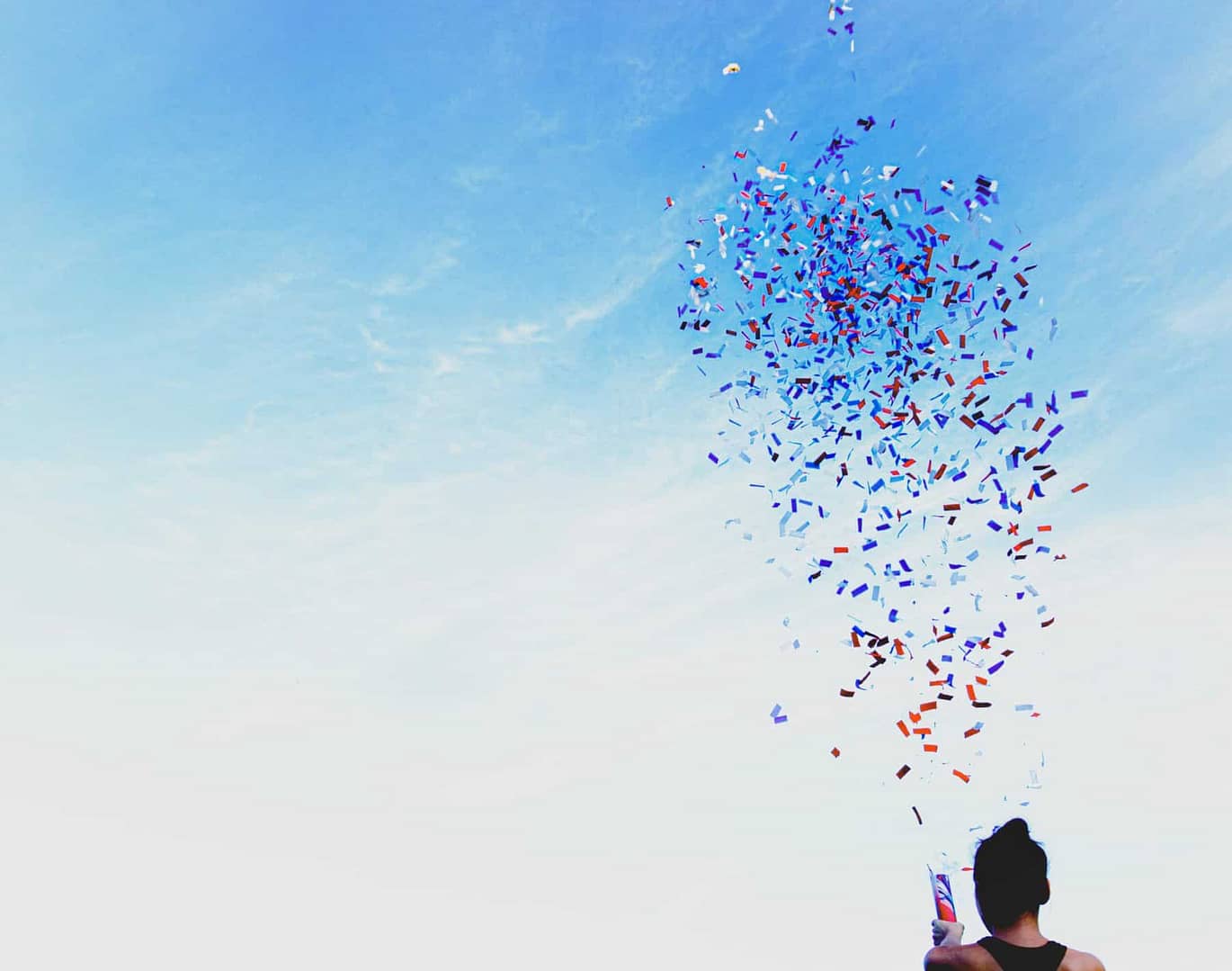 Woman in black tank top celebrating with confetti - National 401k Day 2022