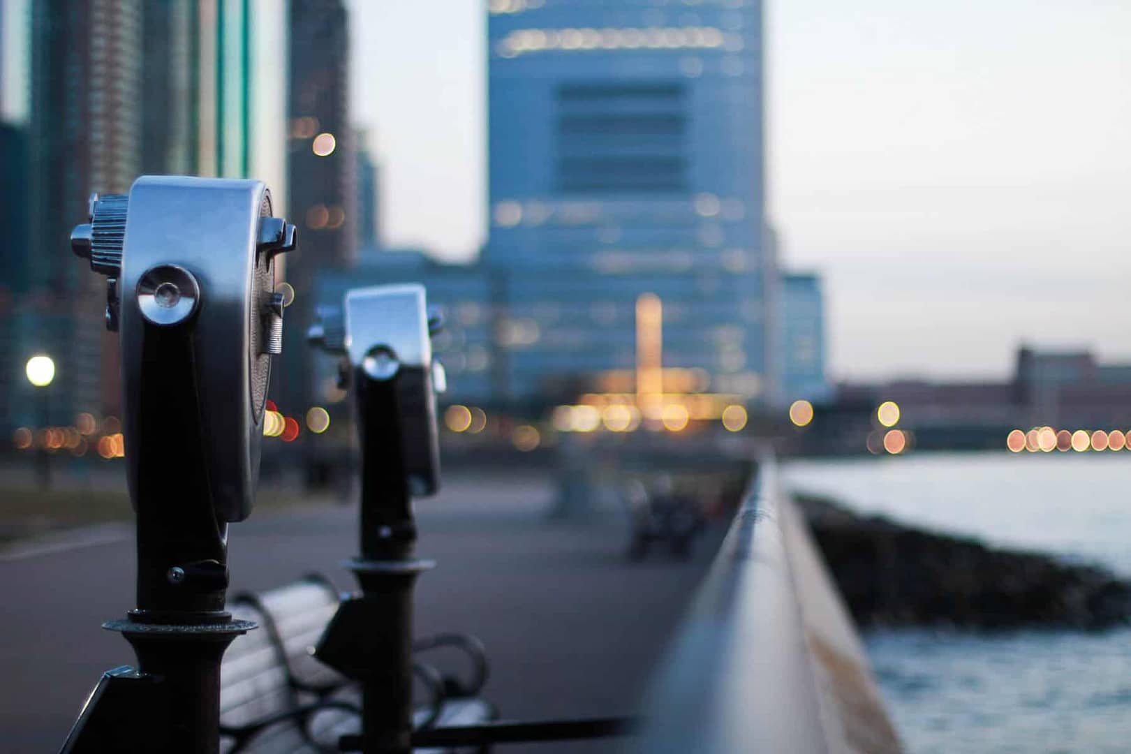 two coin operated scopes besides a rail on the water